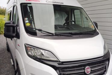 Camping-car blanc garé sous un abri.