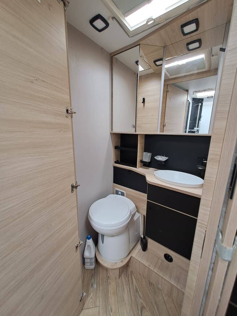 Salle de bain moderne avec toilettes et lavabo.
