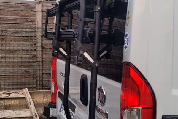 Porte-vélos sur un fourgon stationné, arrière visible.