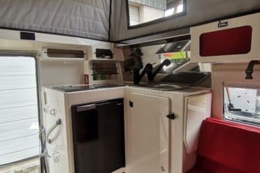 Intérieur d'une caravane moderne avec sièges rouges.