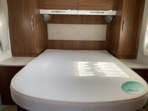 Lit double avec rangements dans camping-car moderne.