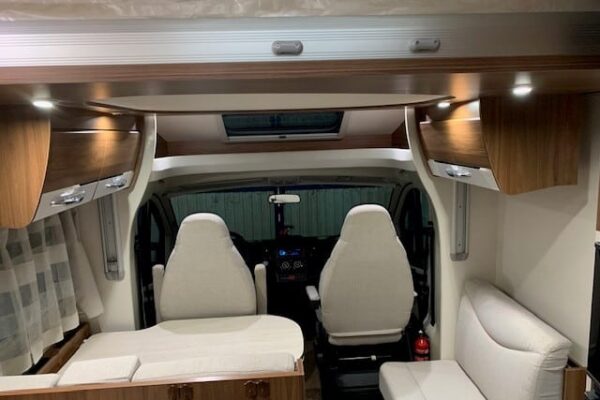 Intérieur d'un camping-car avec sièges et éclairage LED.