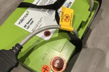 Batterie lithium phosphatée verte avec câbles et étiquettes.