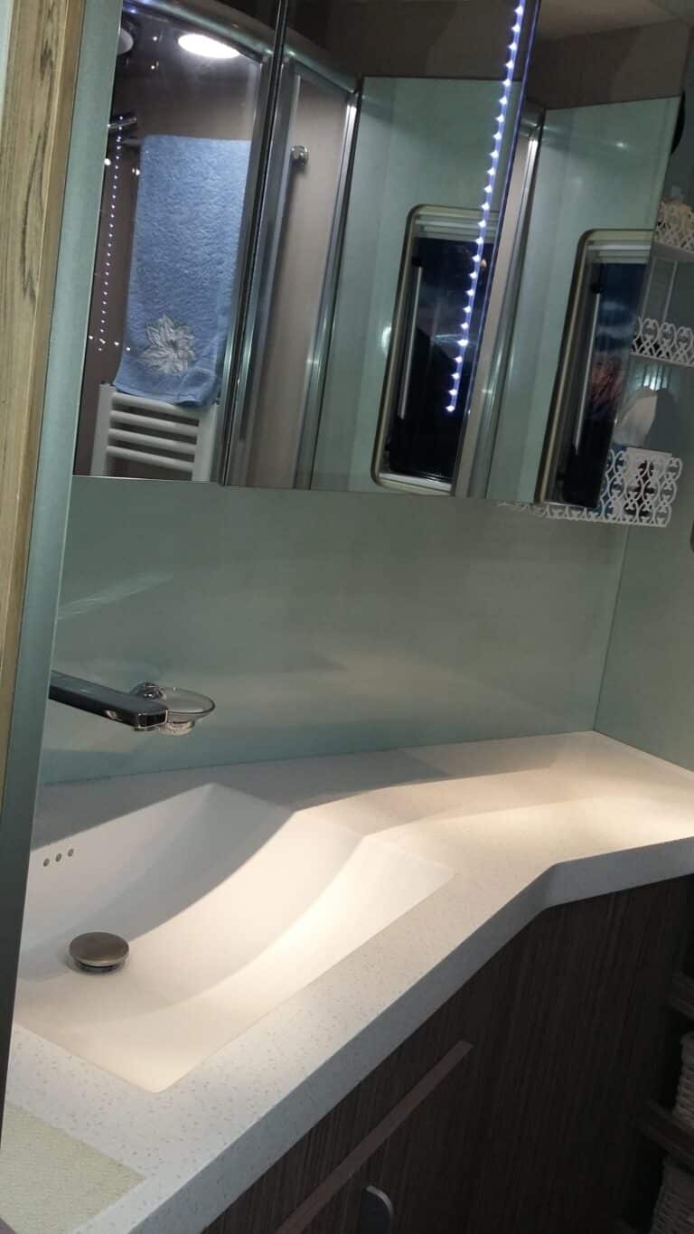 Salle de bain moderne avec lavabo intégré et miroir.