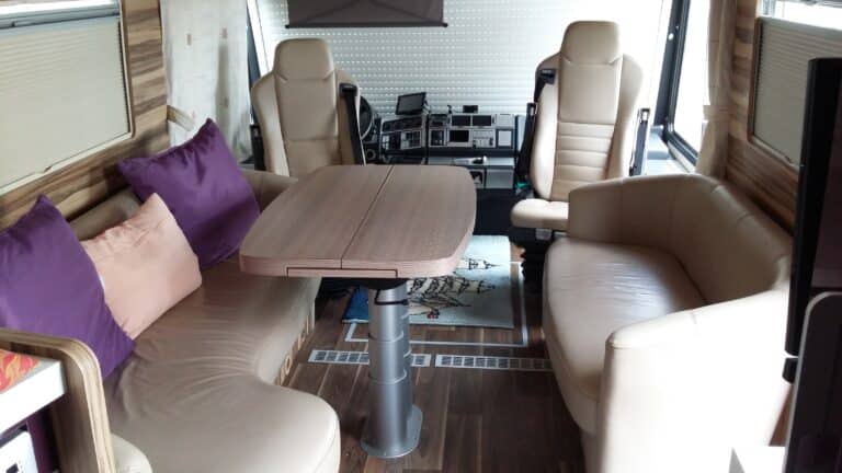 Intérieur d'un camping-car confortable avec table et sièges.