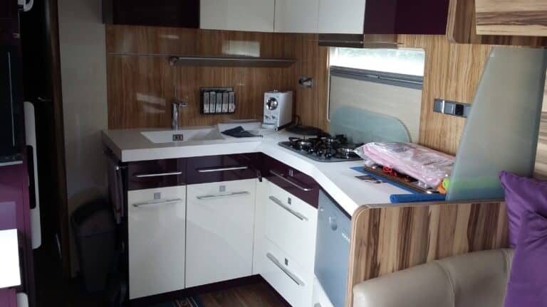 Cuisine moderne compacte avec plan de travail blanc.