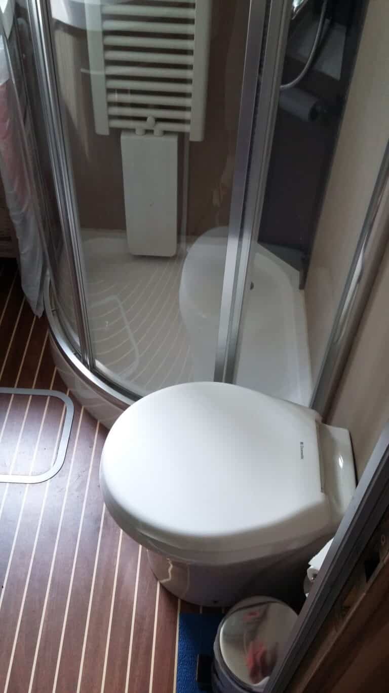 Salle de bain compacte avec douche et toilettes.