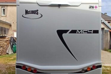 Arrière d'un camping-car McLouis blanc sous ciel nuageux