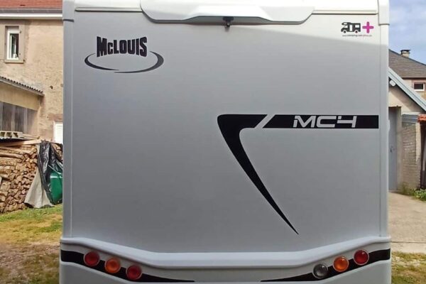 Rückseite eines weißen Wohnmobil McLouis unter bewölktem Himmel