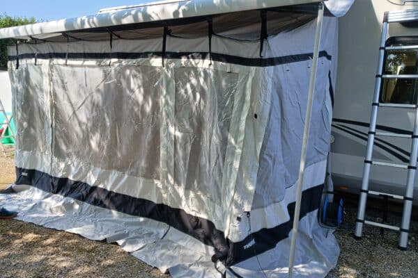 Auvent gris fixé à une caravane en été