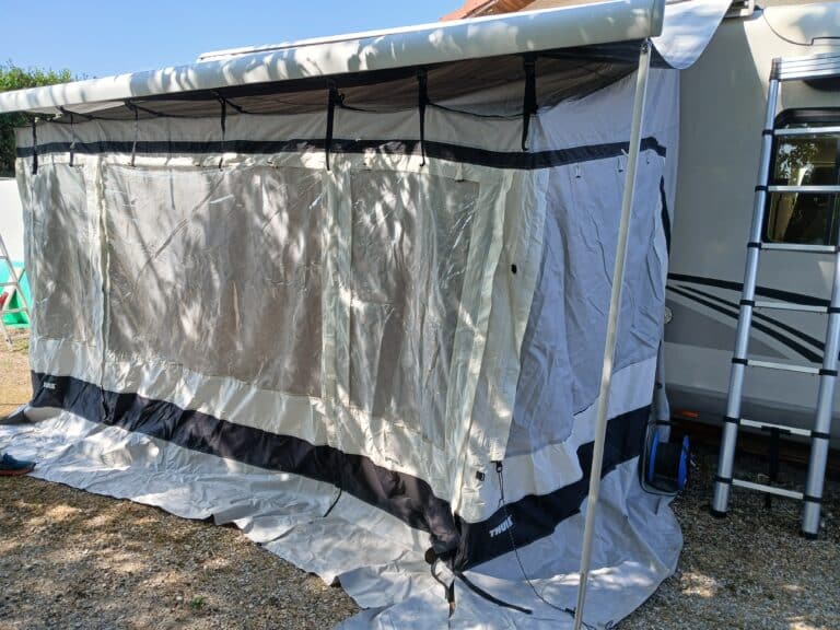 Auvent gris fixé à une caravane en été