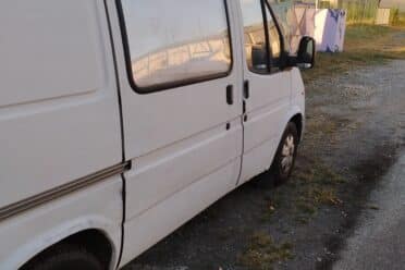 Fourgonnette blanche stationnée sur un terrain gravillonné