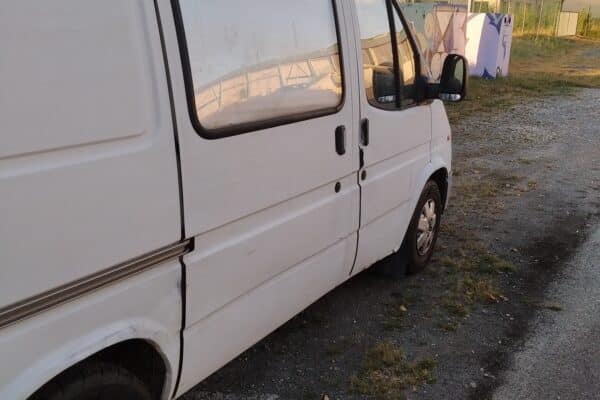 1TP239Weißer Lieferwagen auf einem Kiesplatz geparkt