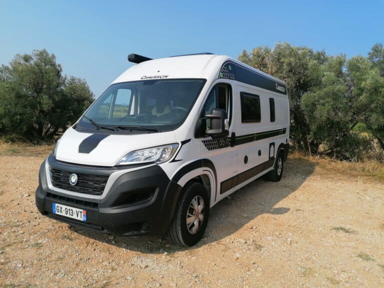 Camping-car blanc stationné en pleine nature