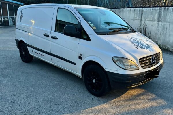 Fourgonnette Mercedes blanche stationnée en extérieur