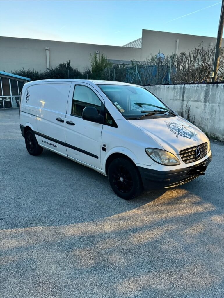 Fourgonnette Mercedes blanche stationnée en extérieur
