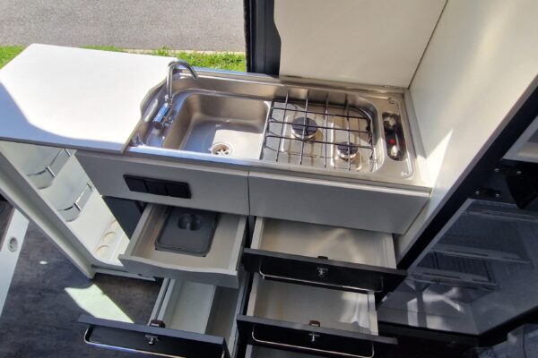 Cucina compatta in un Van camperizzato con lavello e piano di cottura
