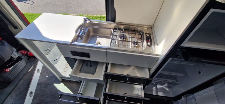 Cuisine compacte dans un van aménagé avec évier et réchaud