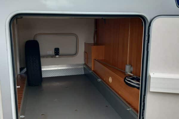 Coffre ouvert de camping-car avec rangements en bois