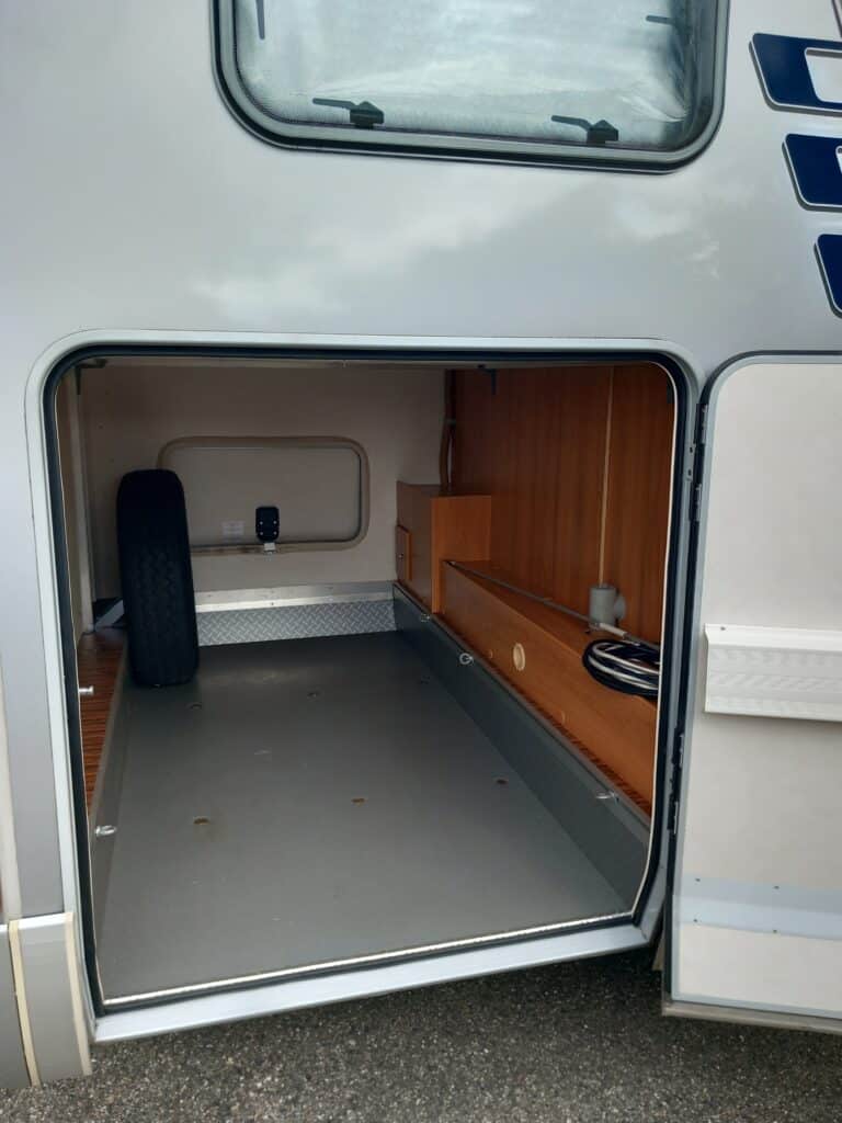 Coffre ouvert de camping-car avec rangements en bois
