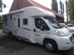 Camping-car Rapido blanc garé à côté d'une maison