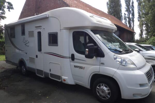 Camping-car Rapido blanc garé à côté d'une maison