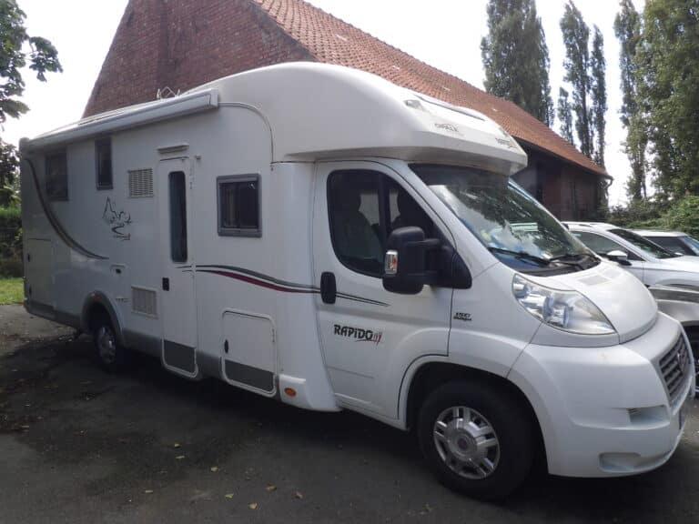 Camping-car Rapido blanc garé à côté d'une maison
