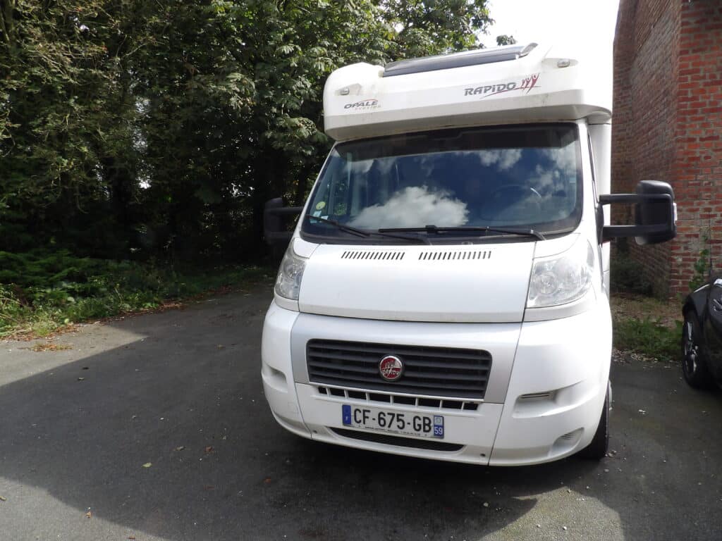 Camping-car Rapido blanc garé près d'une maison