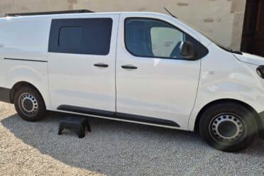 Fourgonnette blanche garée près d'un bâtiment