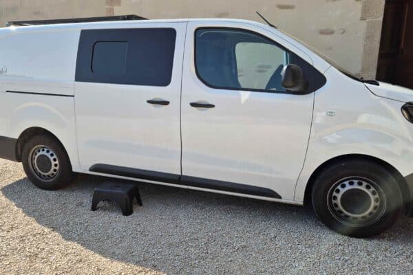 Fourgonnette blanche garée près d'un bâtiment