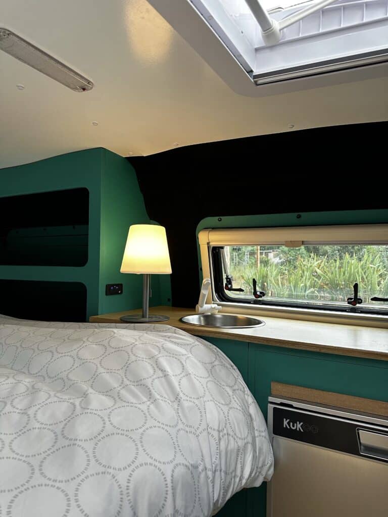 Intérieur cosy de camping-car avec lit et lampe