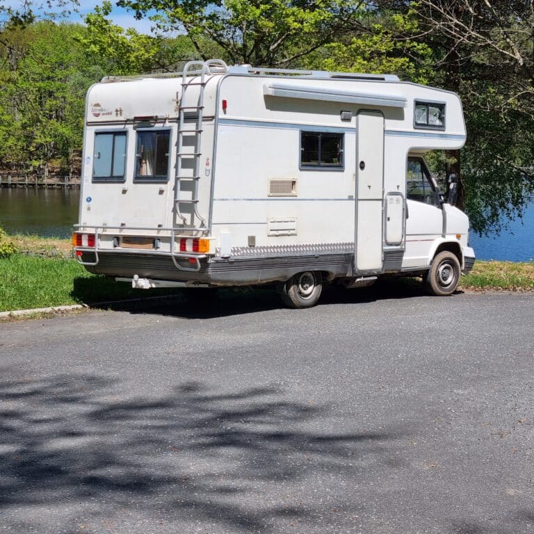 Camping-car blanc garé près d'un lac