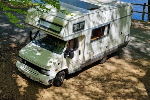 Wohnmobil weiß geparkt an einem See