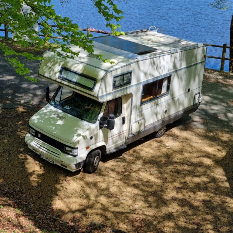 Camping-car blanc garé près d'un lac