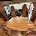 Intérieur de camping-car avec sièges et table en bois