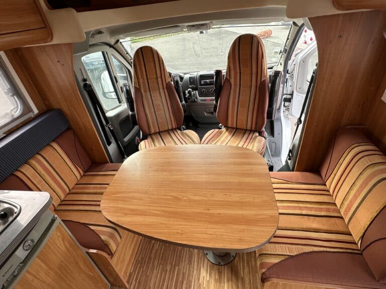 Intérieur de camping-car avec sièges et table en bois