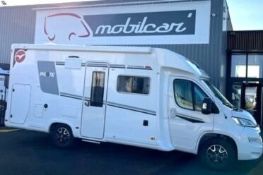 Camping-car blanc devant concessionnaire Mobilcar