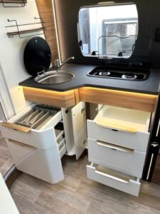 Cuisine compacte, moderne avec évier et tiroirs ouverts