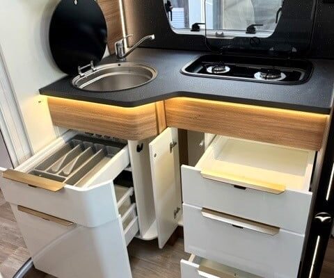 Cuisine compacte, moderne avec évier et tiroirs ouverts