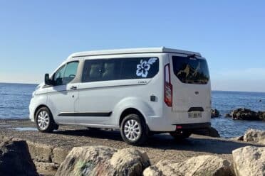 1TP272Furgone bianco parcheggiato in riva al mare