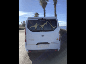 Fourgon blanc Ford Transit stationné face à la mer