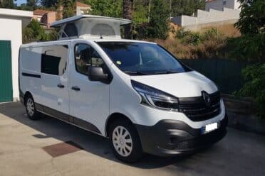 Fourgonnette blanche avec toit ouvrant stationnée